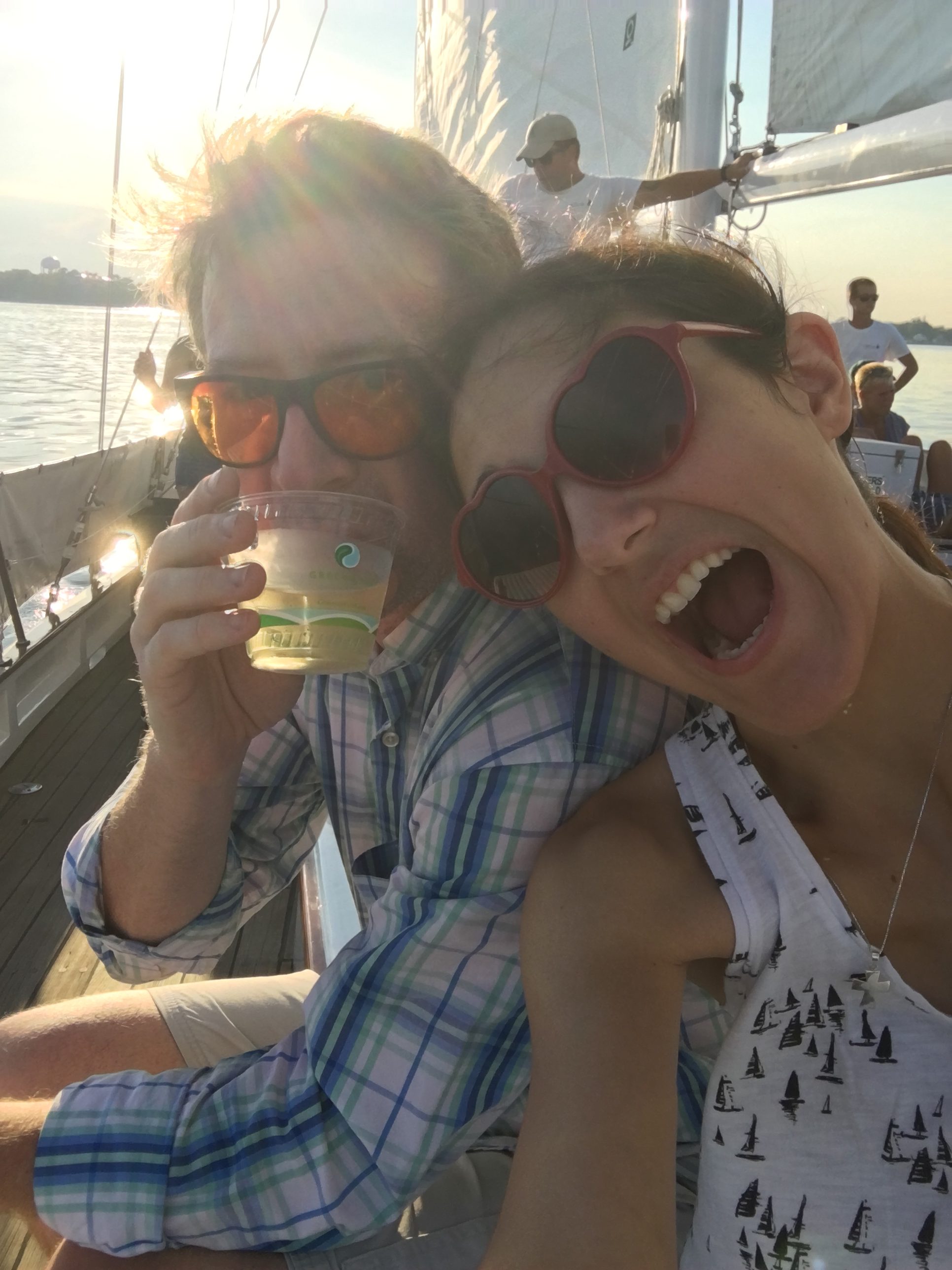 Young couple enjoying drink and sailing on a beautiful day