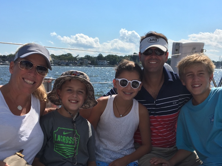 Smiling family sailing on a sunny bright day