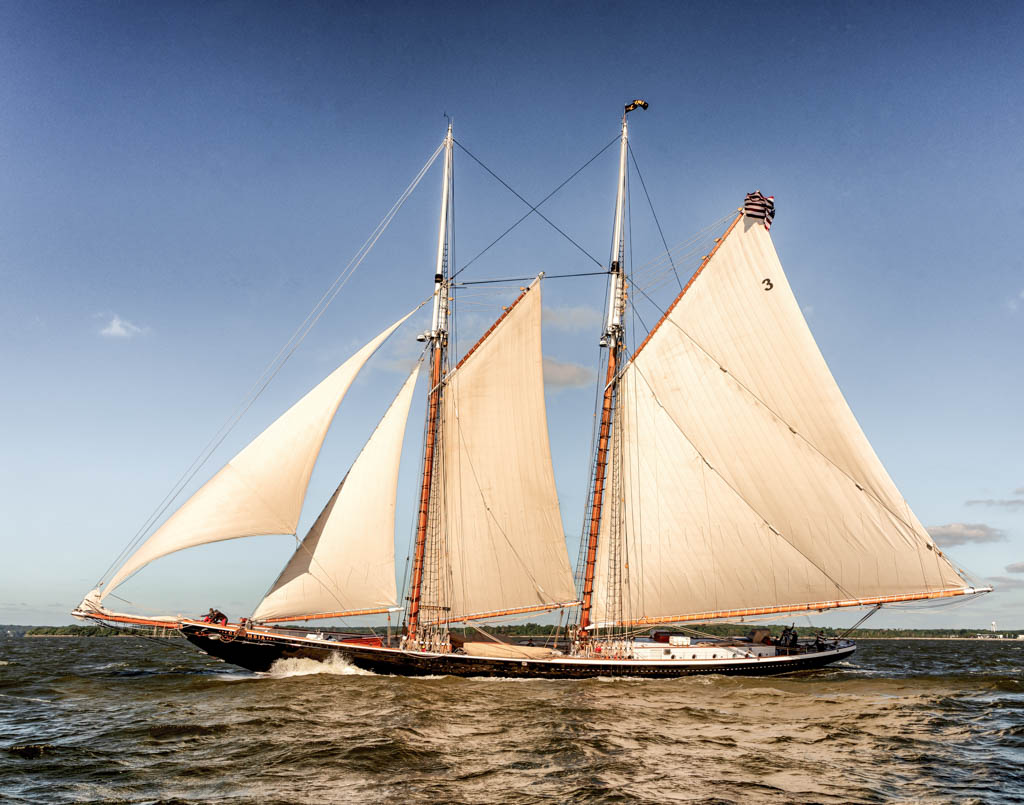 Schooner under sail with blue skies and deep blue water