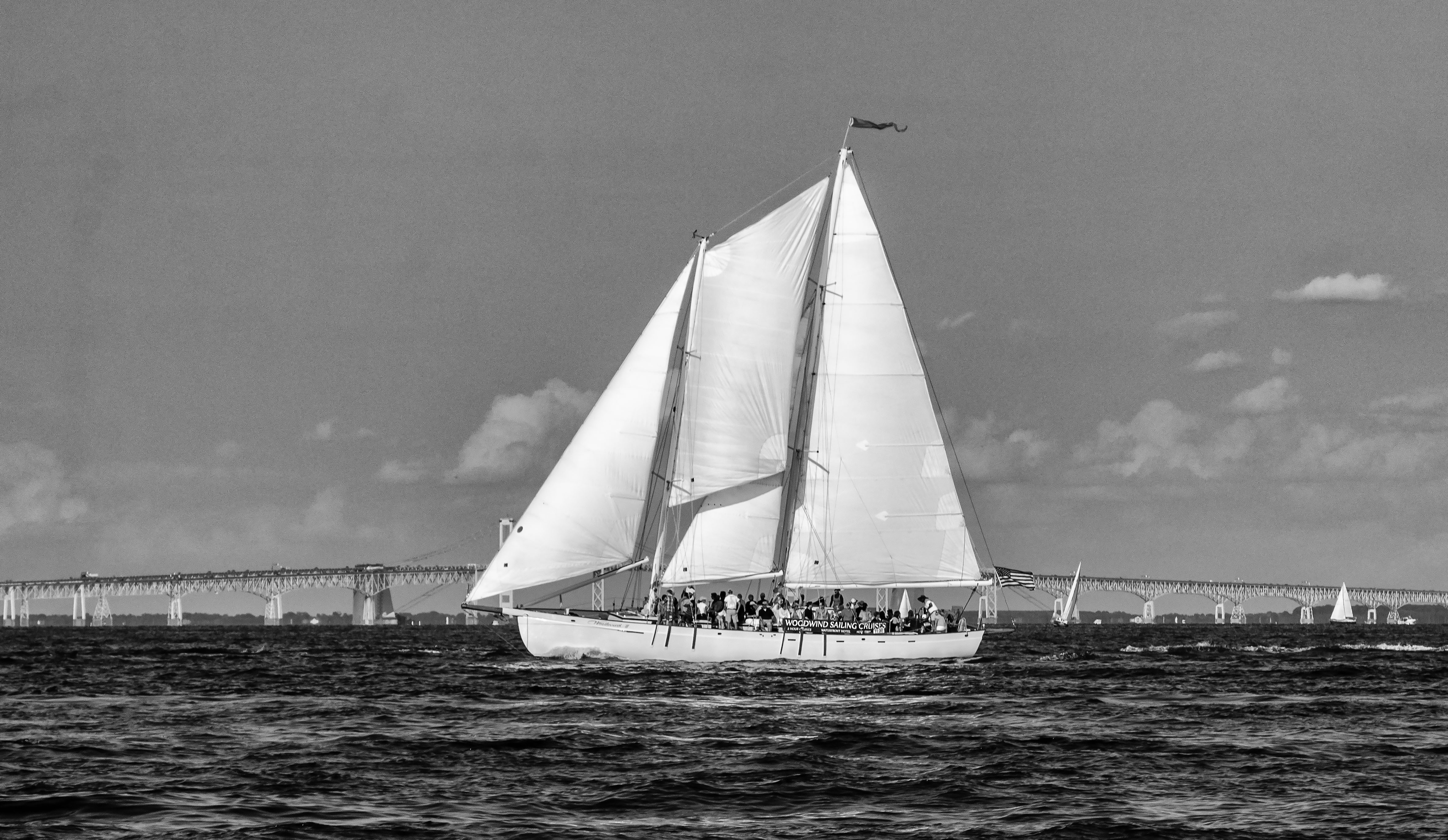 Black and white photo of the Schooner sailing in front of Bay Bridge