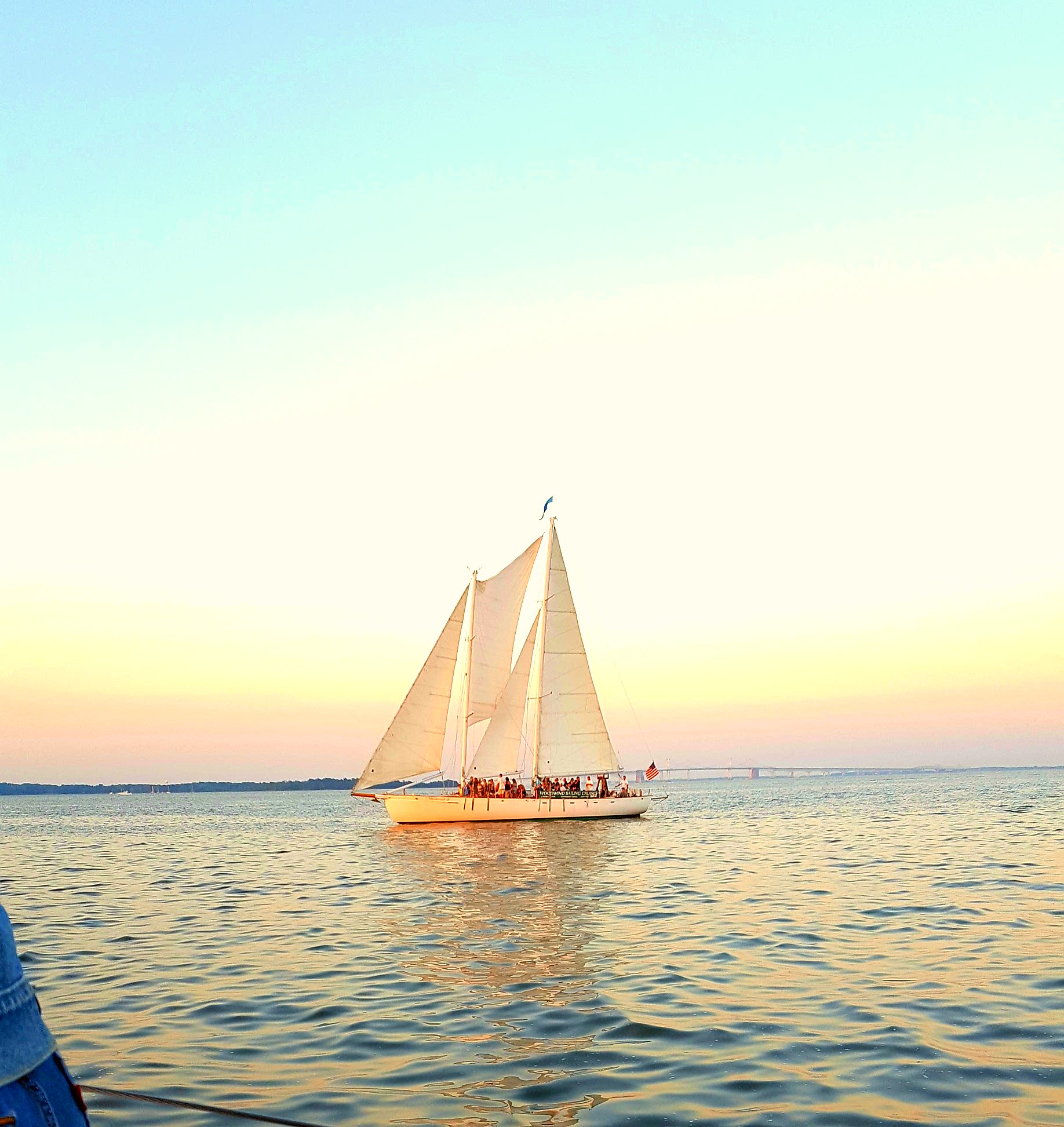 Schooner sailing into a beautiful blue water sunset