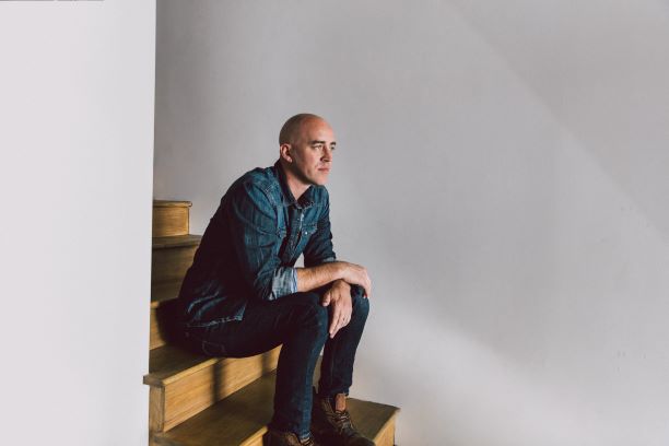 Entertainer Tyrone Wells sitting on steps