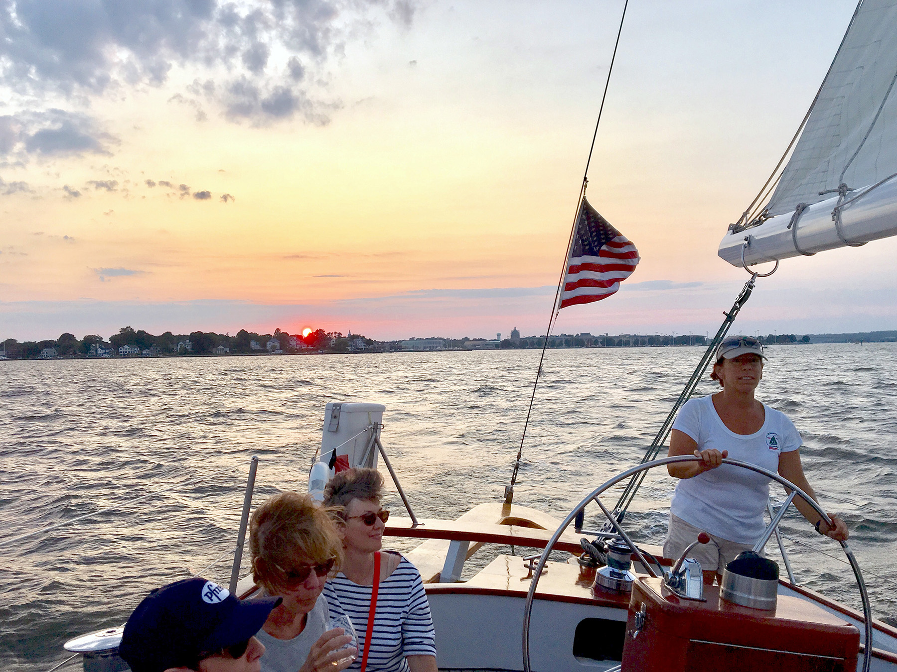 Schooner being captained at sunset with American Flag flying