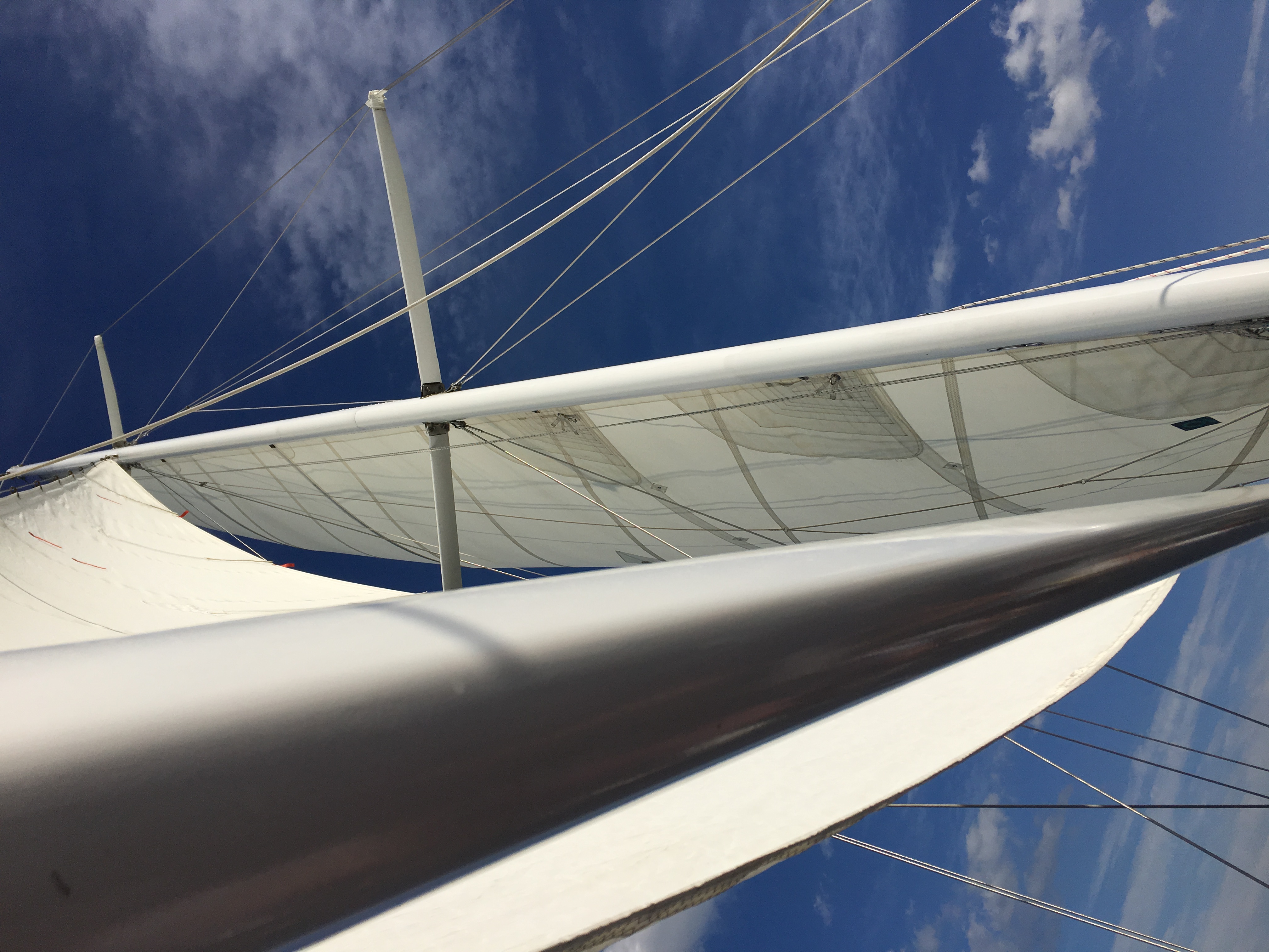 Looking up through white sails into a Blue sky