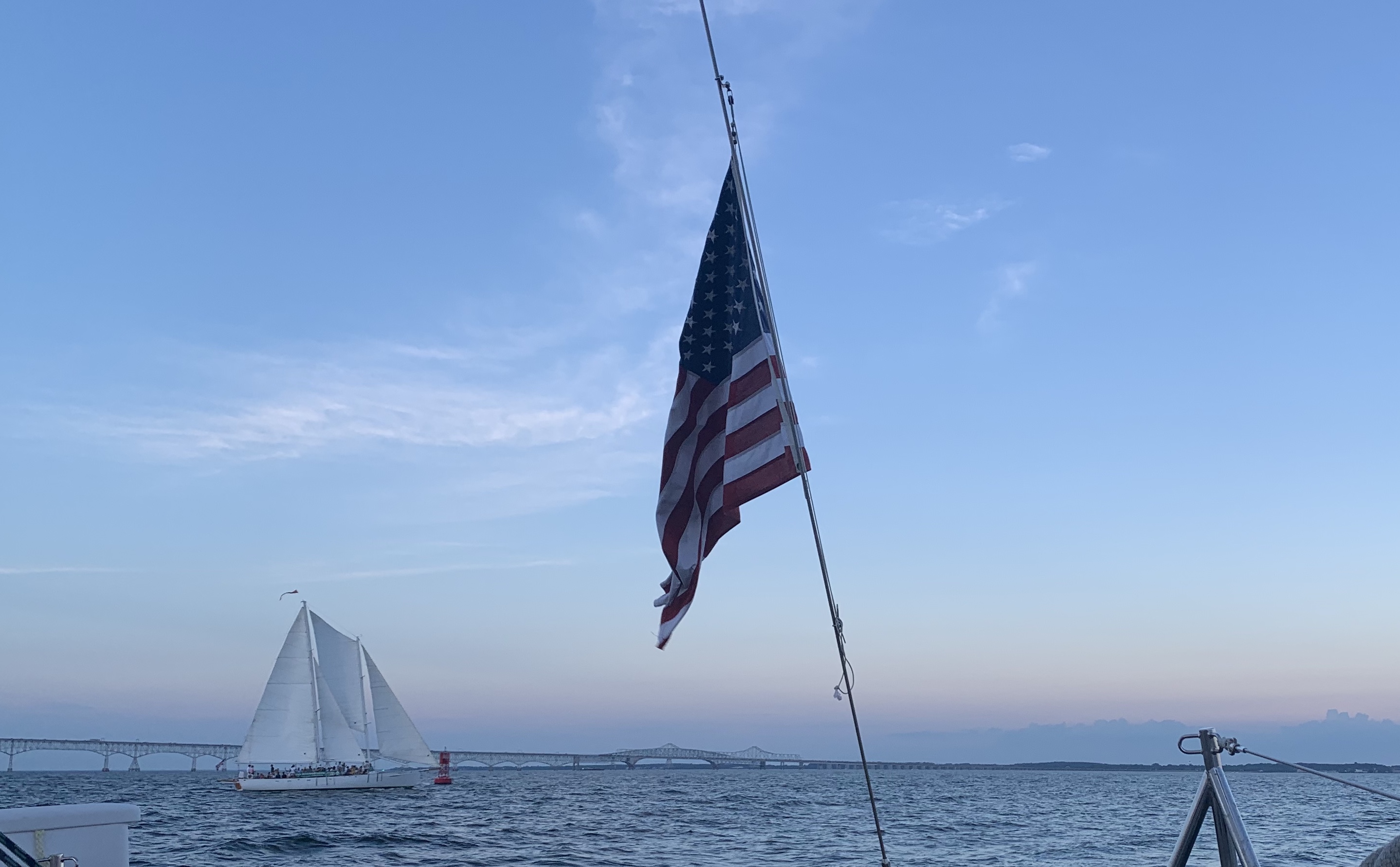 Bay Bridge with Woodwind sailing by it and American Flag