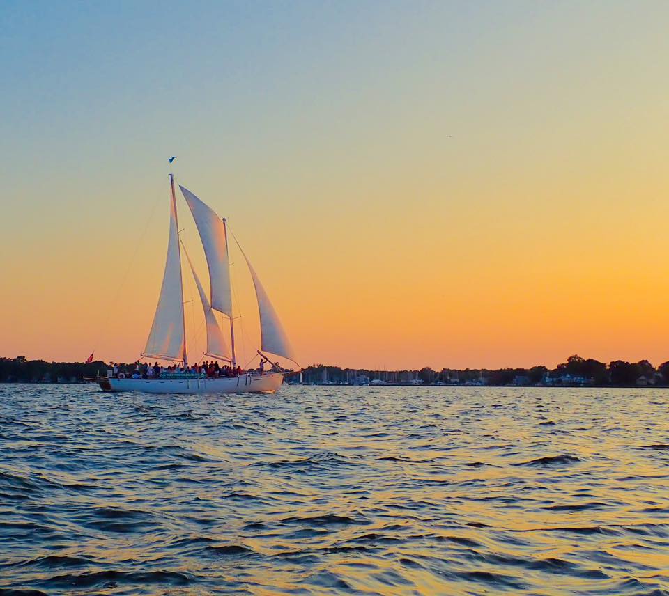 Schooner framed by mellow yellow sunset and blue waters